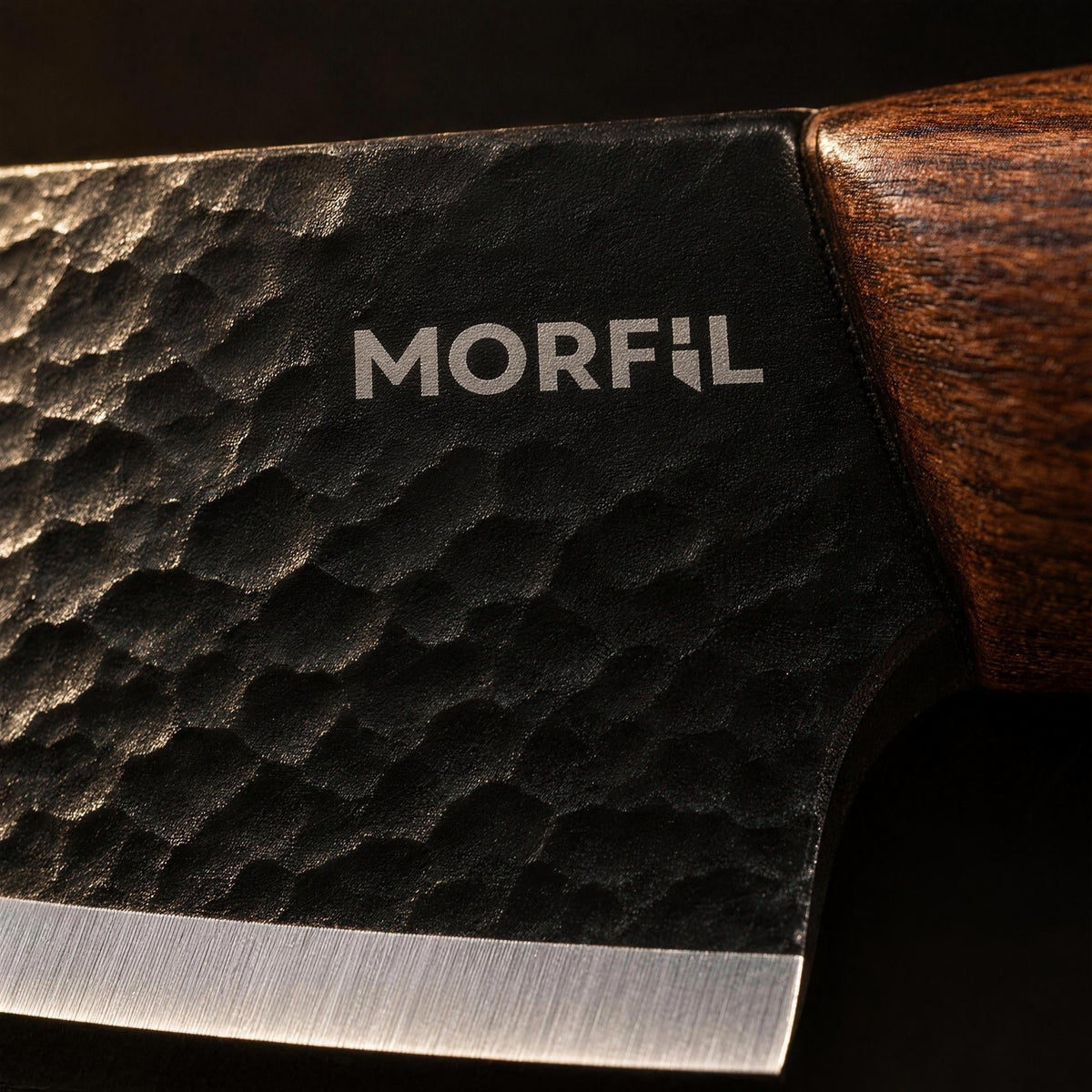 Gros plan sur le logo Morfil gravé au laser près du talon de la lame, texture martelée noire