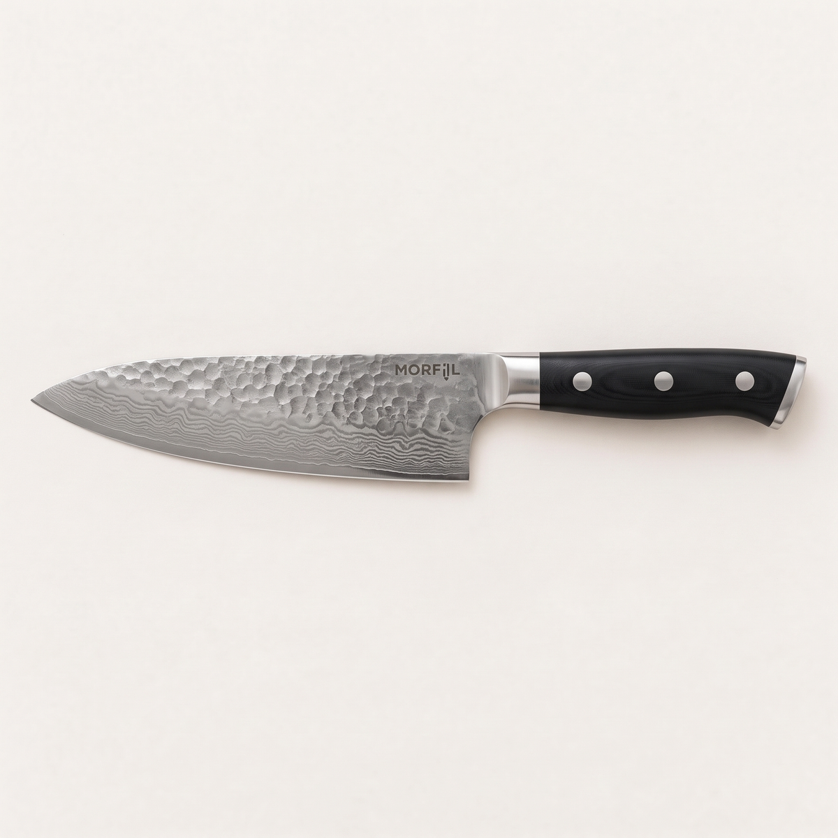Petit couteau de chef Étincelle de Morfil vu de dessus sur fond clair : lame martelée au motif ondulé, mitre inox et manche noir à trois rivets