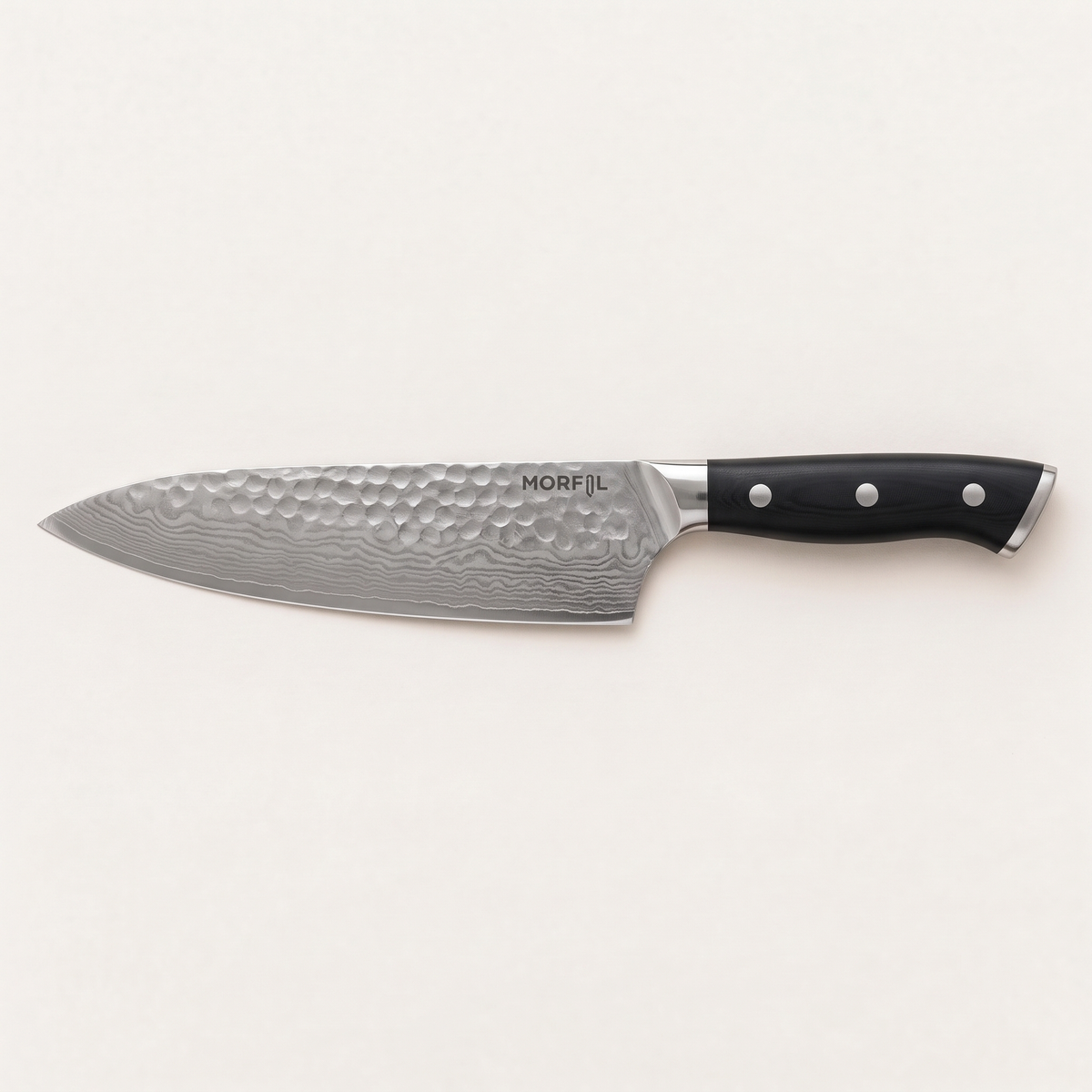 Couteau de chef Foyer de Morfil vu de dessus sur fond clair : lame de 20 cm martelée au motif ondulé, mitre inox et manche noir à trois rivets