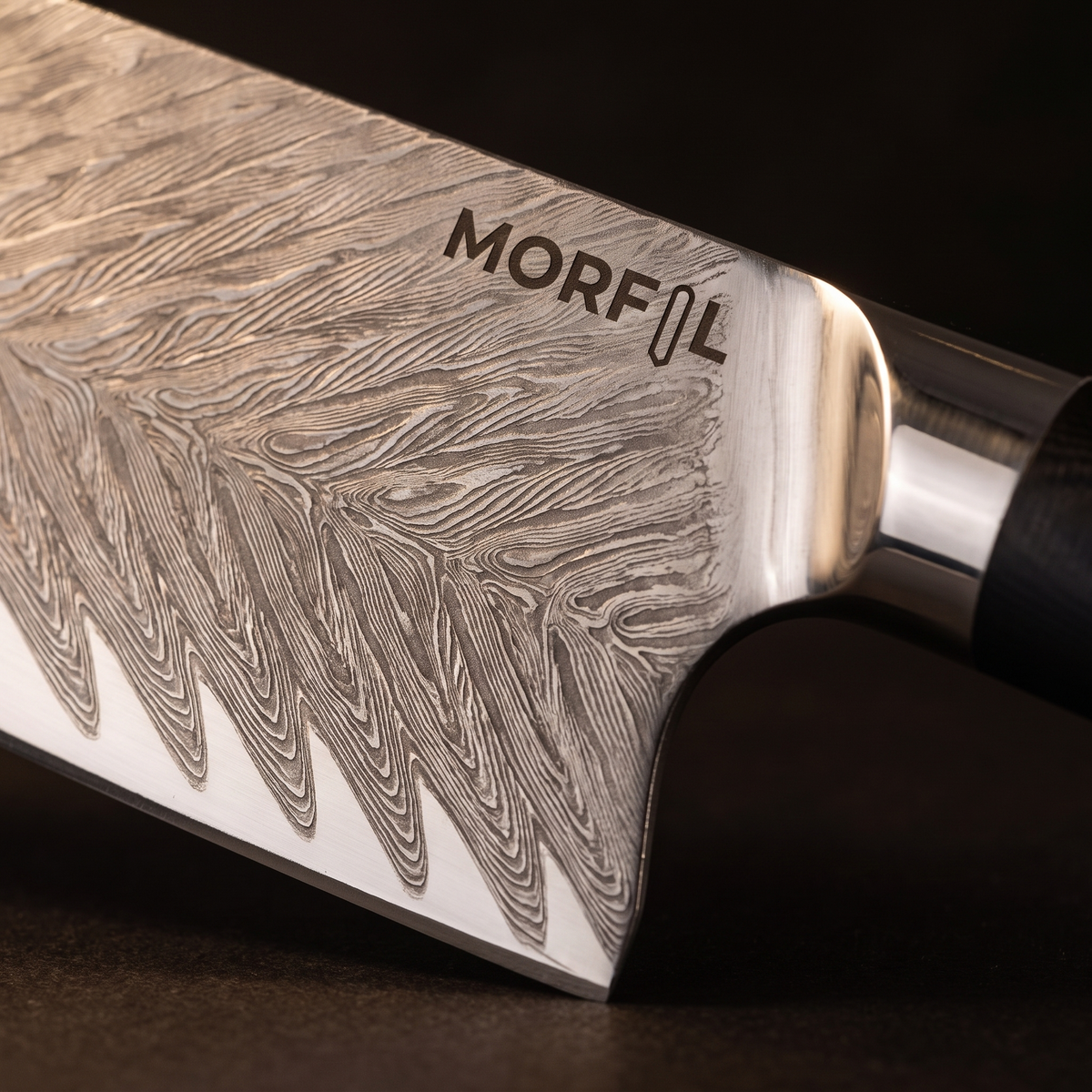 Gros plan sur le motif ondulé en chevrons de la lame de Fumée, la mitre inox et le logo Morfil gravé